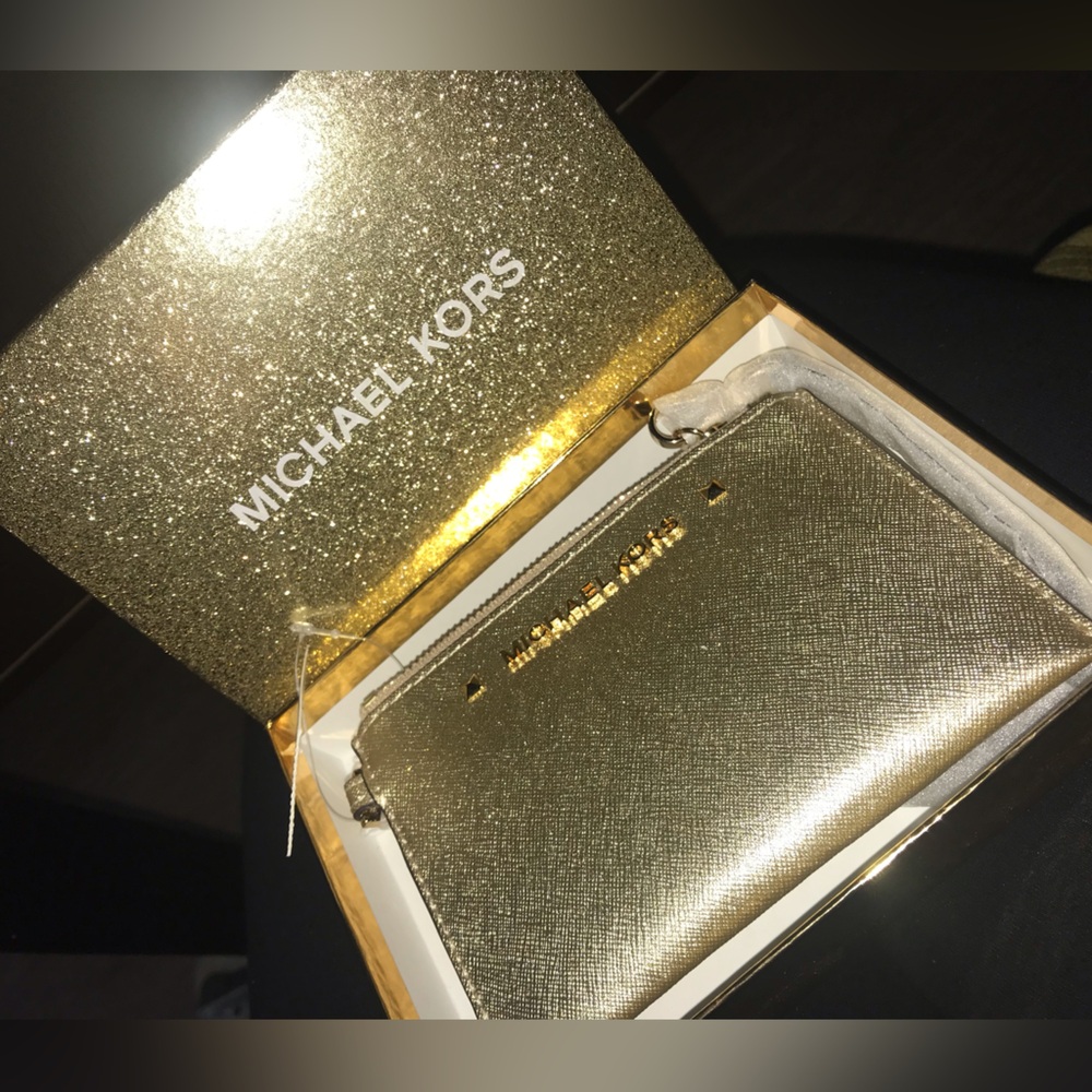 new with tags, wristlet in the color gold. W/Michael Kors sparkle gift box.